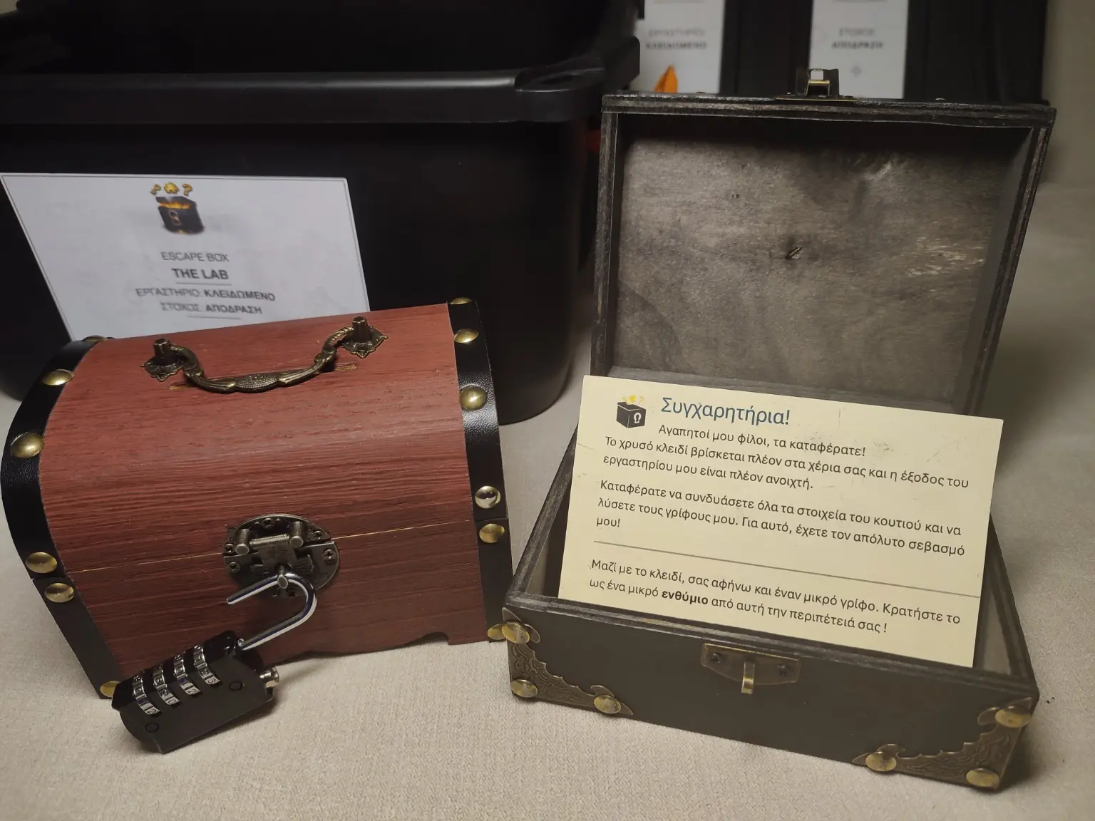 Escape box - 2 premium props τύπου escape room: Ένα σεντούκι κλειδωμένο και ένα ανοικτό. Φαίνεται η κάρτα συγχαρητηρίων ολοκλήρωσης του παιχνιδιού